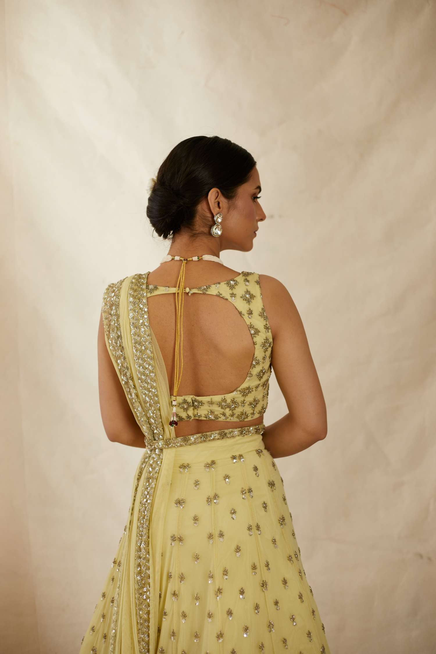Back Angle view of Yellow Net Crepe Embroidered Lehenga Set