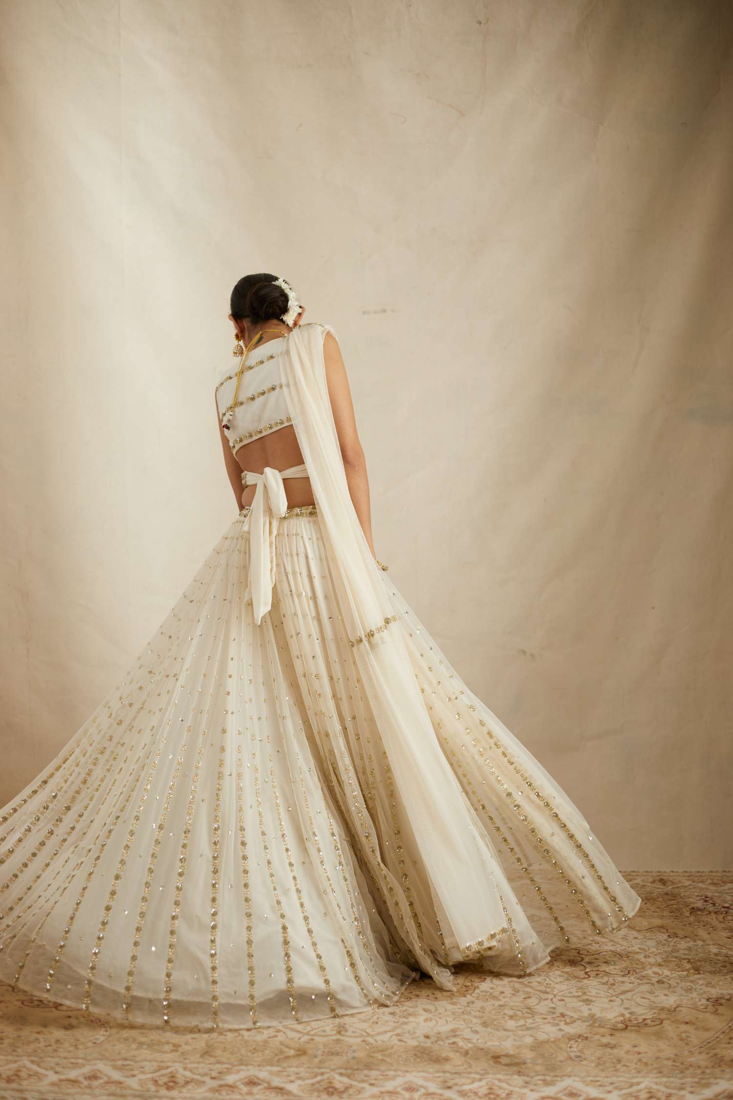Back Angle of Off White Net Crepe Line Embroidered Lehenga Set